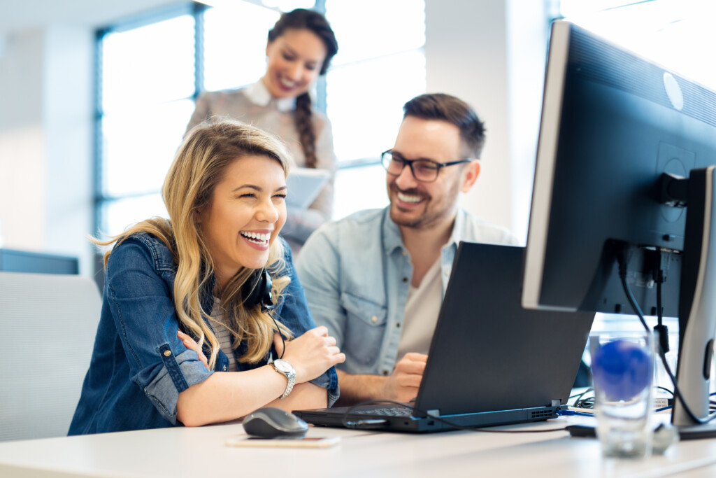 3 Perosnen vor einem PC lachen