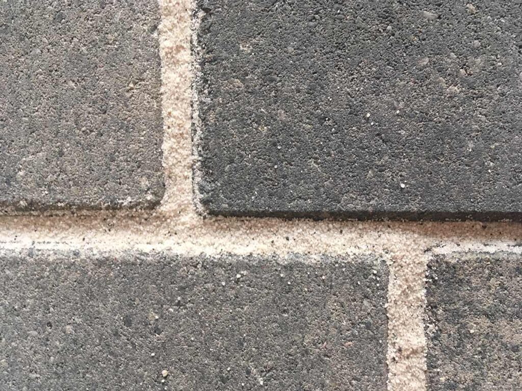 Heller Fugensand zwischen dunklem Pflaster