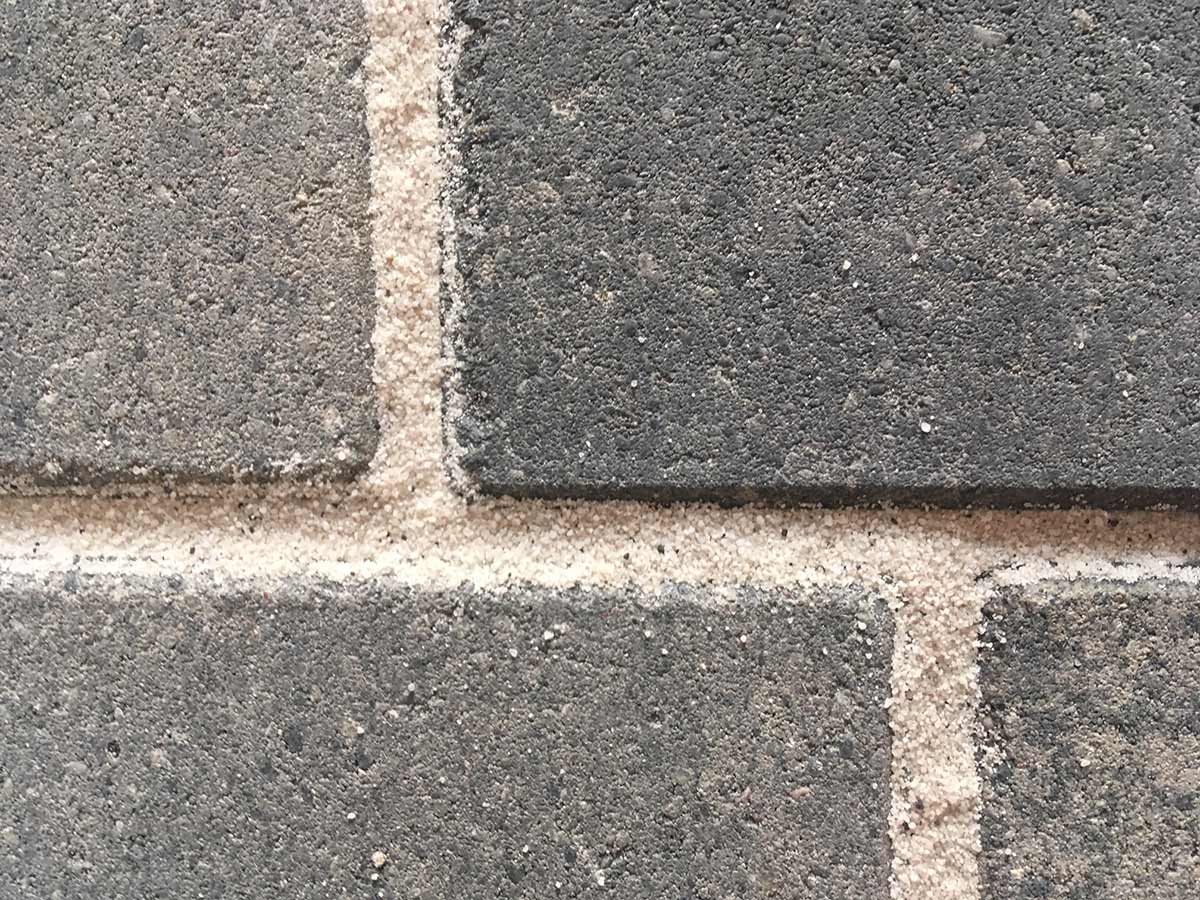 Heller Fugensand zwischen dunklem Pflaster