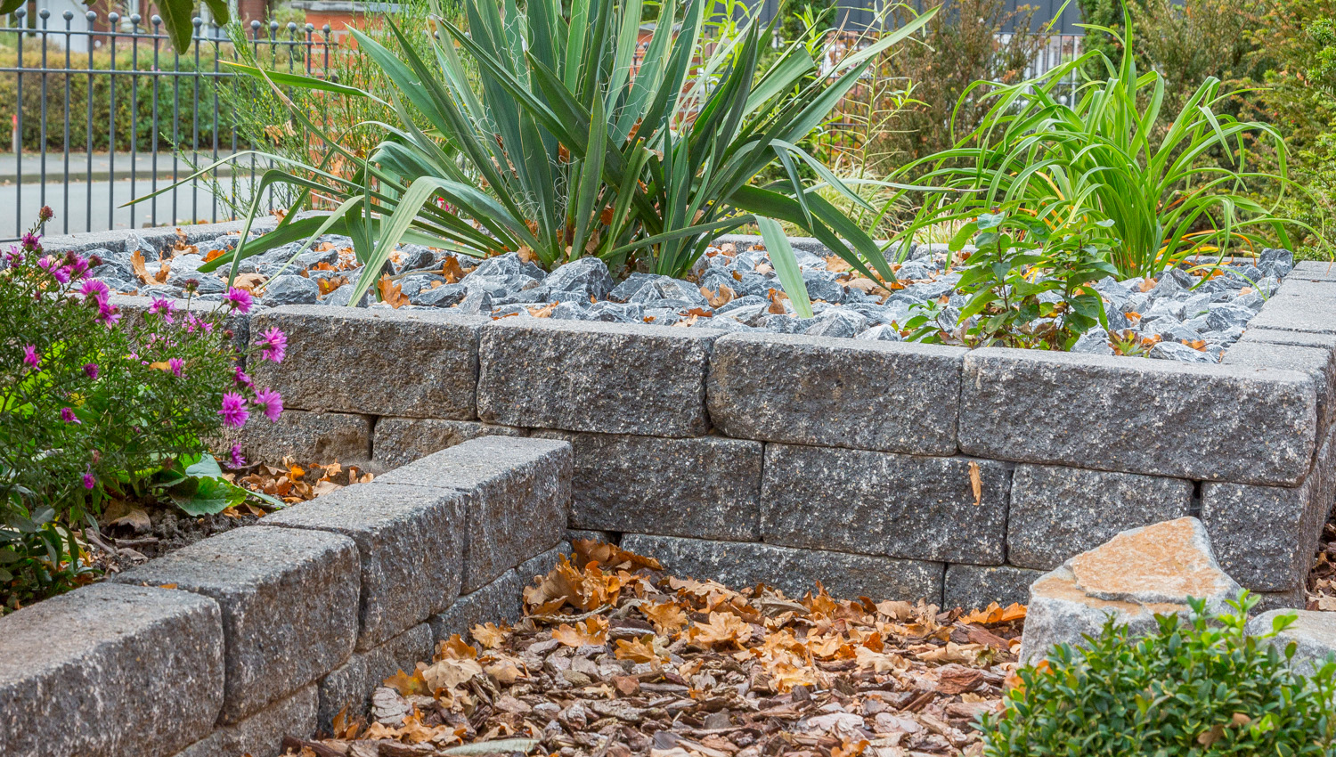 Mauersteine in Anthrazit mit Blumen