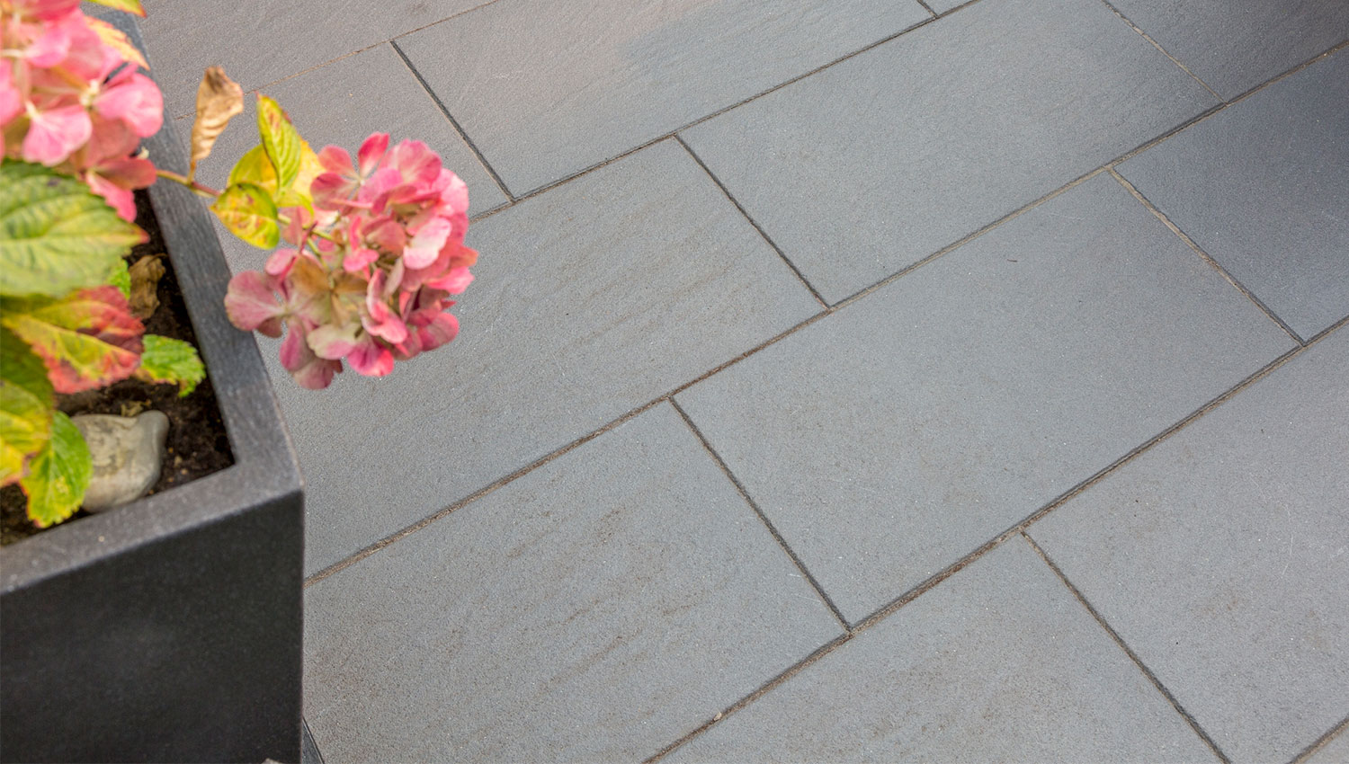 Graue Terrassenplatten mit Blumen